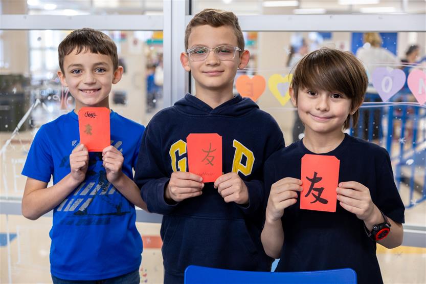 Students make red envelopes in the library